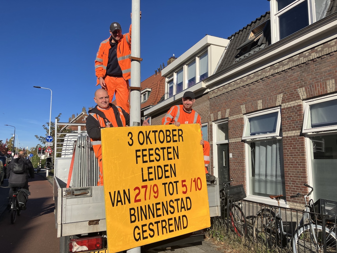 Medewerkers van beheer halen het bord van de lantaarnpaal. (Foto: Facebook Gemeente Leiden).