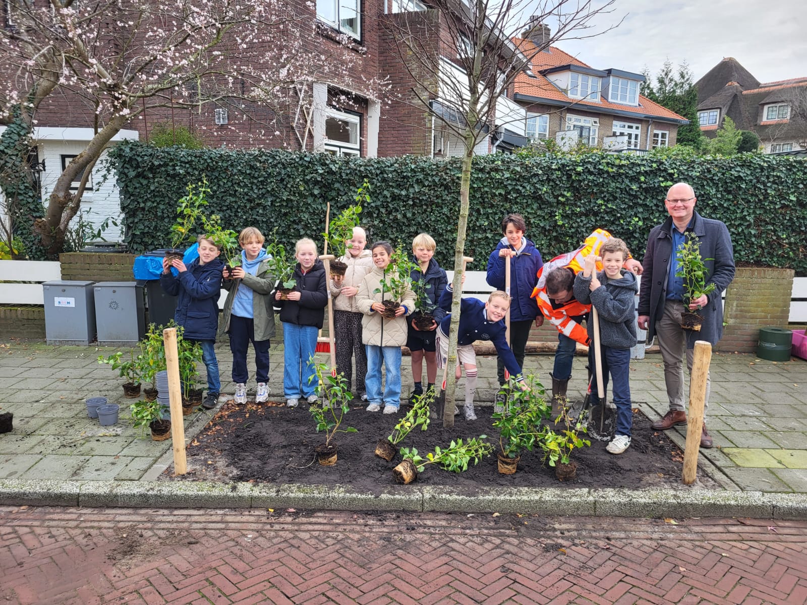 De kinderen mochten samen met de wethouder de bomen planten