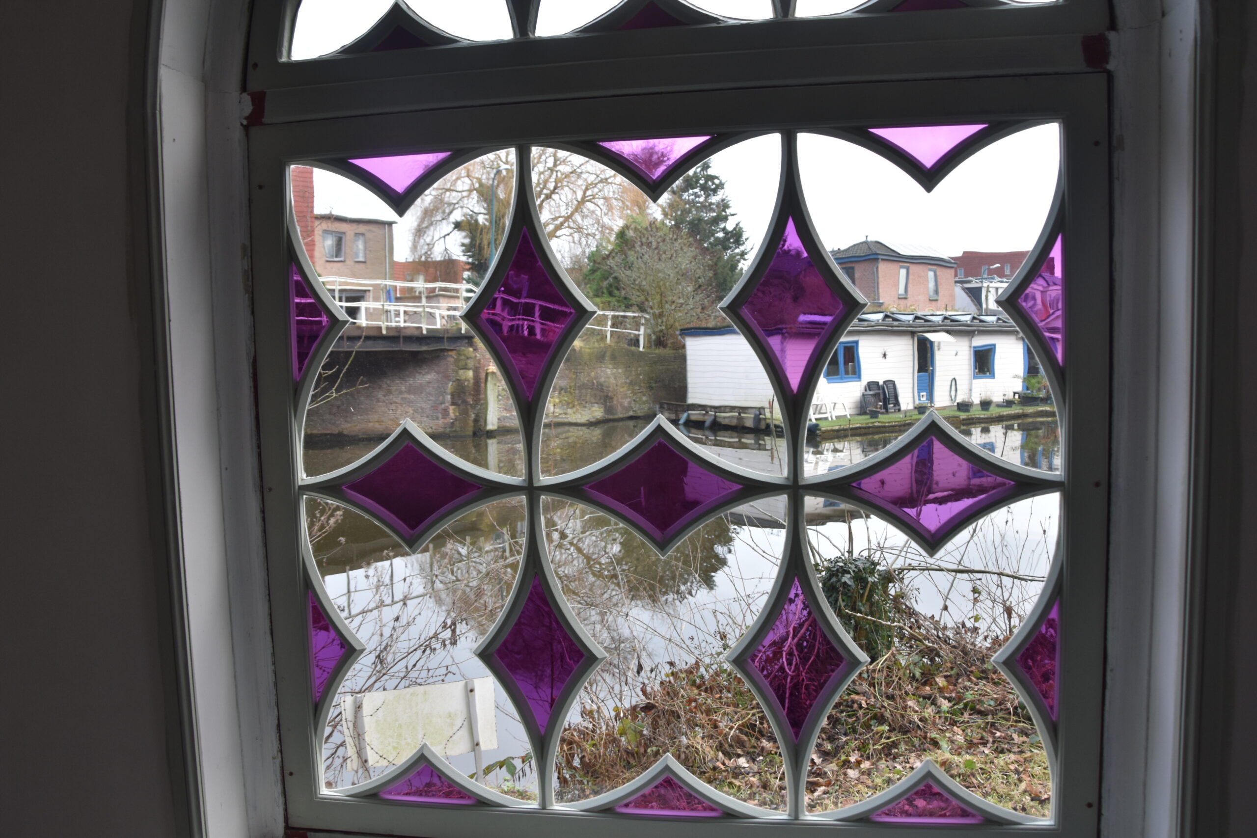 Uitzicht op de Haarlemmertrekvaart door het nieuwe raam van de kapel