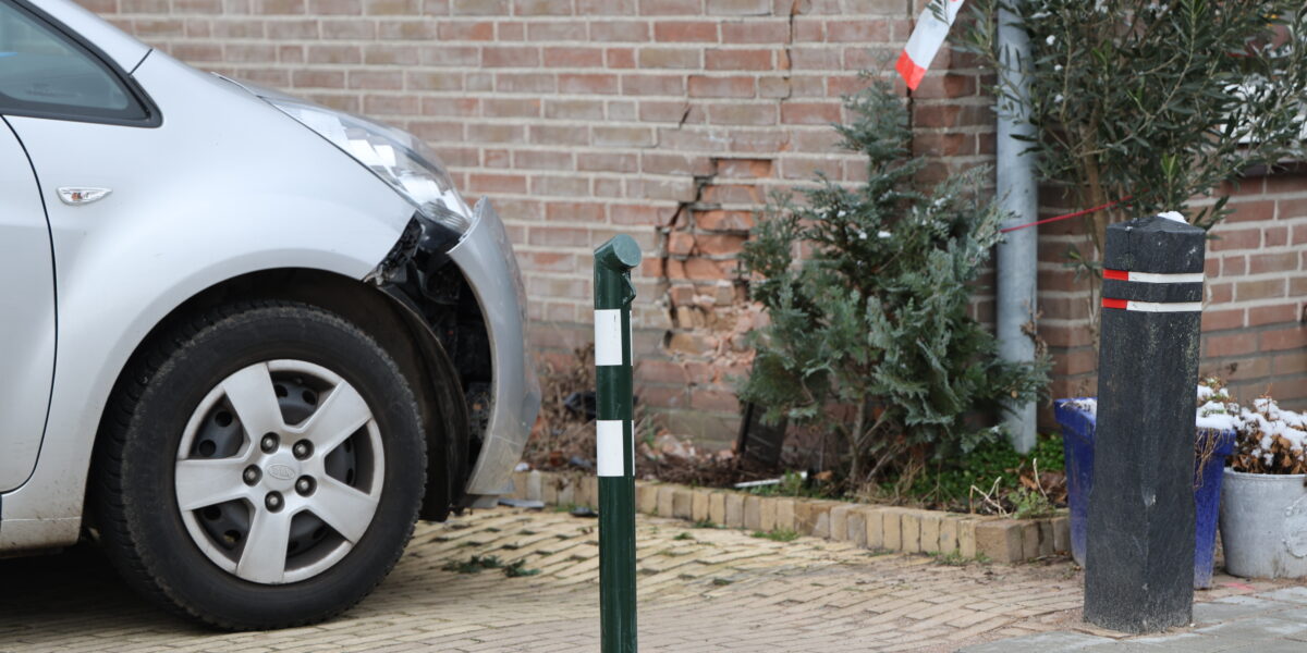 Auto schiet uit parkeervak tegen gevel: bestuurder gewond