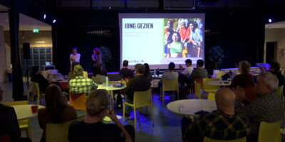 Leekrachten van het Visser 't Hooft Lyceum zitten in de aula en kijken naar een presentatie van Dealbreakers.