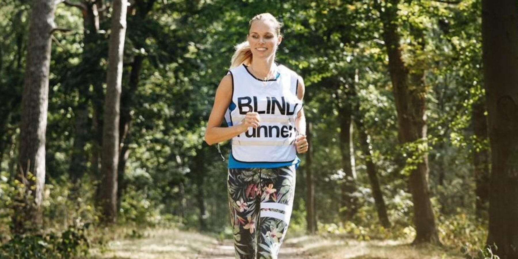 Burgemeester Tjarda Struik is blind runner en rent door het bos met haar hond.