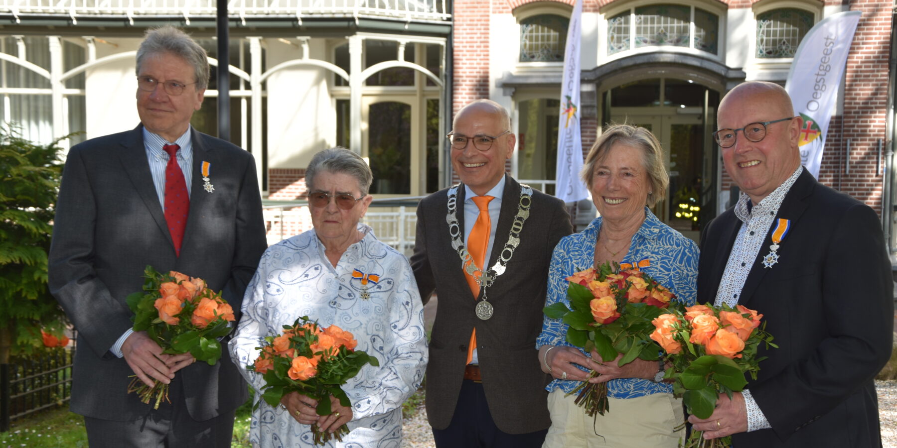 De lintjesregen in Oegsgeest met de 4 decorandi op en burgemeester Jaensch