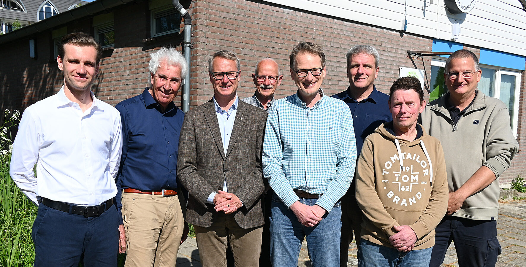 Op deze foto is een groep mensen te zien. Dit zijn leden van het bestuur van Ijsclub Voorschoten. En wethouder Hubert Schokker van de gemeente Voorschoten. Er is tussen beide partijen een nieuwe huurovereenkomst getekend die de bouw van een combibaan mogelijk maakt.