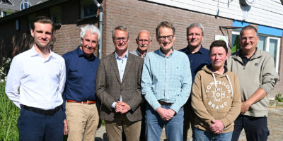 Op deze foto is een groep mensen te zien. Dit zijn leden van het bestuur van Ijsclub Voorschoten. En wethouder Hubert Schokker van de gemeente Voorschoten. Er is tussen beide partijen een nieuwe huurovereenkomst getekend die de bouw van een combibaan mogelijk maakt.