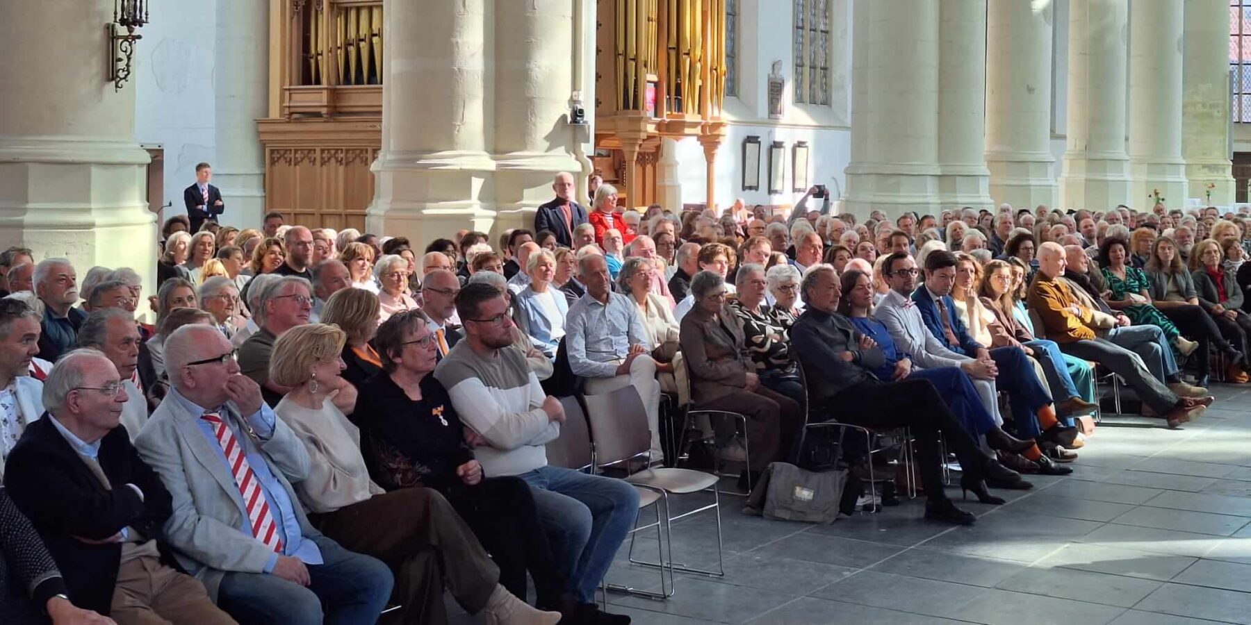 Een groot zittend publiek in de Hooglandse Kerk tijdens de lintjesregen.