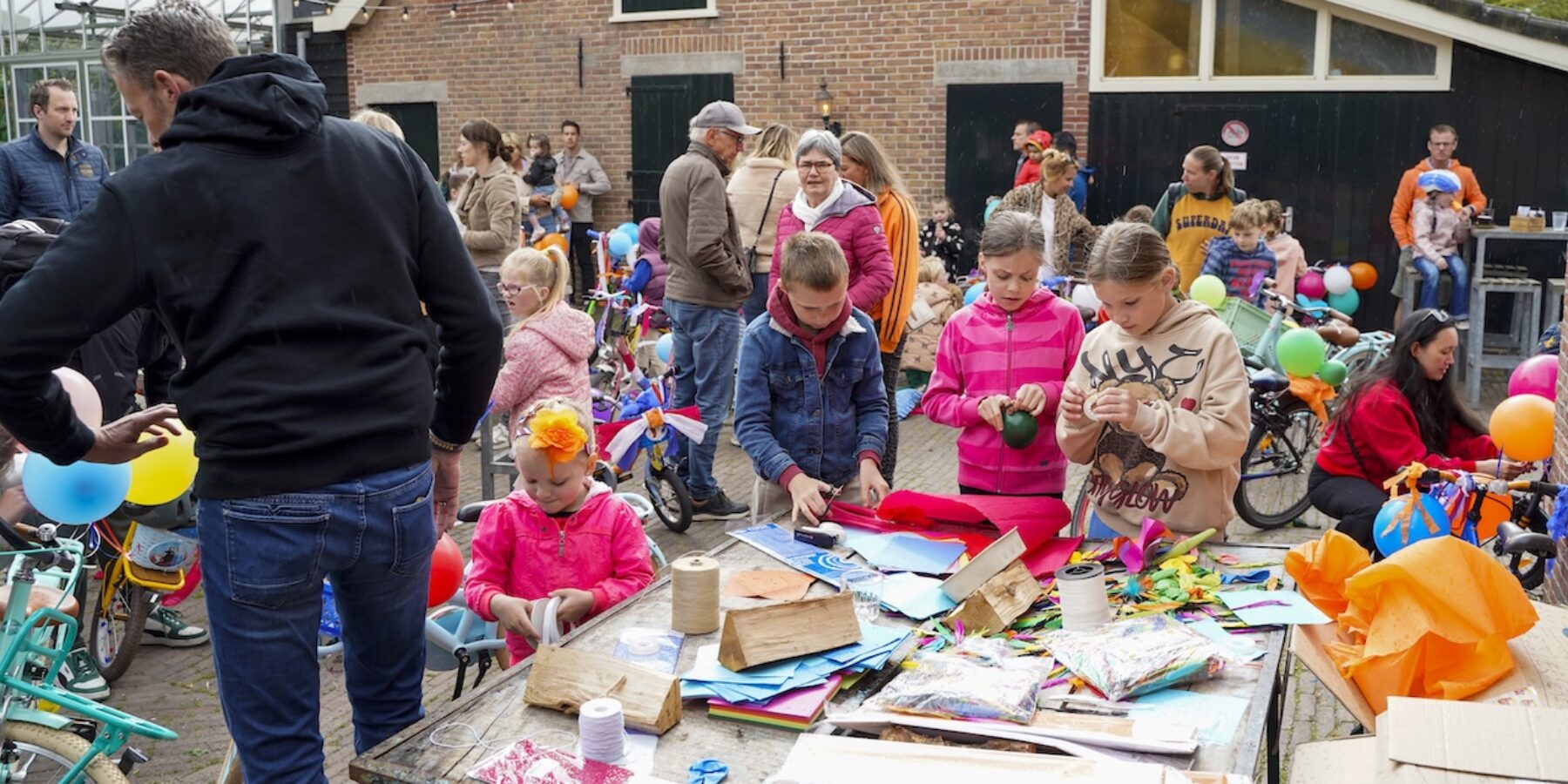 Kinderen versieren fietsen op Bevrijdingsdag bij Brasserie Park in Leiderdorp.