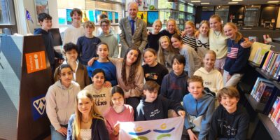 Leerlingen van de Herenwegschool en burgemeester Leendert de Lange poseren voor de tentoonstelling