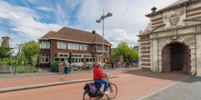 Een illustratie van een fietser die naar een van de Leidse stadspoorten rijdt.