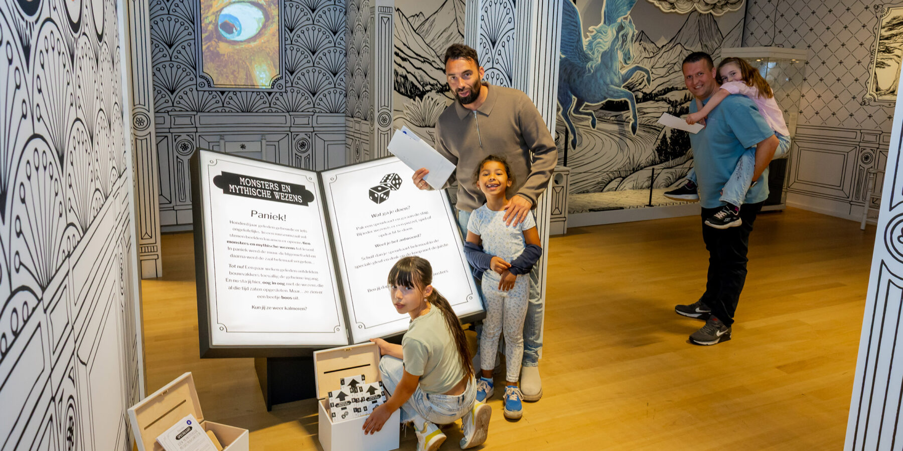 Een gezin poseert in het Rijksmuseum van Oudheden bij de tentoonstelling 'Monsters en Mythische wezens'