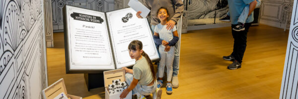 Een gezin poseert in het Rijksmuseum van Oudheden bij de tentoonstelling 'Monsters en Mythische wezens'