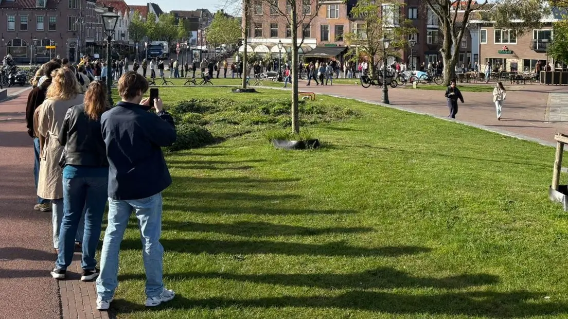 Een lange rij van mensen die een kaartje willen kopen bij Petit Restaurant De Valk voor de Singelloop.