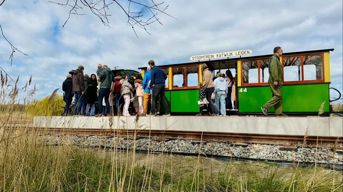 Mensen betreden de Stoomtrein Katwijk Leiden, die langs het Valkenburgse Meer rijdt.