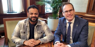 Presentator Rudo Slappendel en burgemeester Peter Heijkoop van de gemeente Leiden lachen voor de foto.