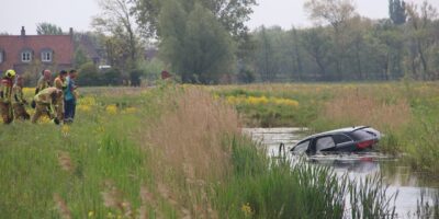 De auto in het water langs de Ruigelaan in Wassenaar. De hulpdiensten zijn ter plaatse.