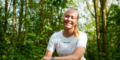 Dena Bandt in haar sportkleding, in een bos.