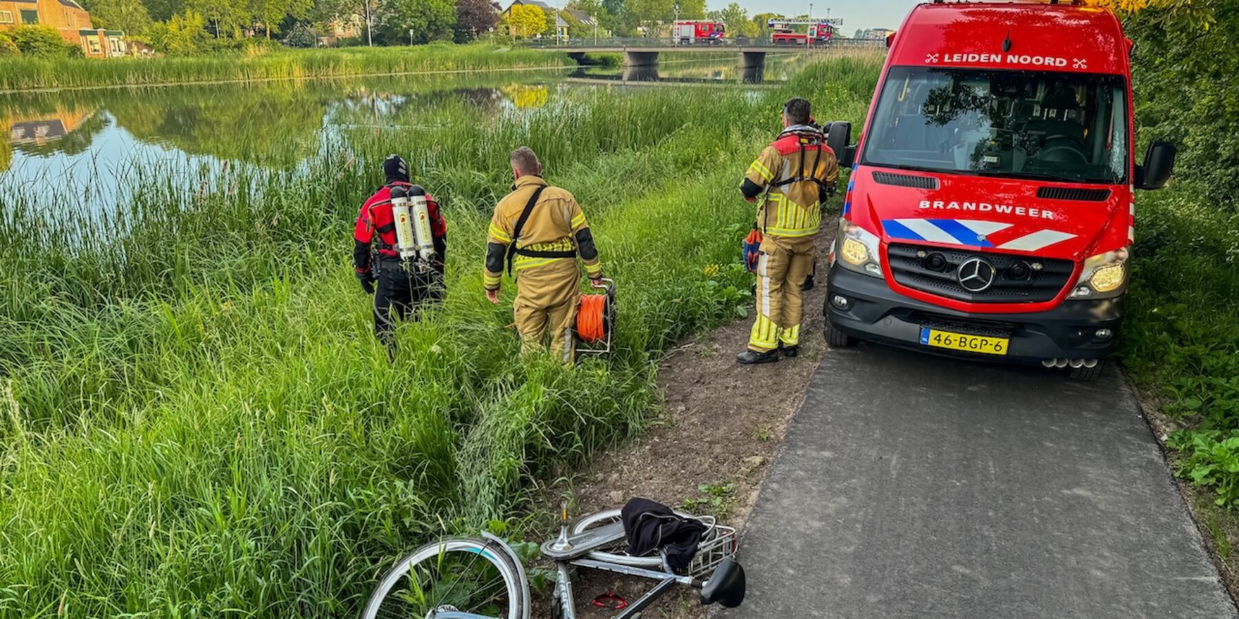 Fiets en spullen langs het water bij Sportpark de Bloemerd in Leiderdorp. De brandweer rukt groots uit.