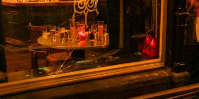 Een gat in de ruit van de gevel van Café de Uyl aan de Nieuwstraat in Leiden. Een man is door de ruit gevallen.