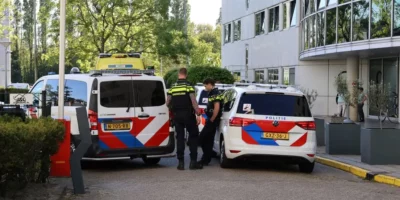 Een politiebusje, politiewagen en twee politieagenten zijn aanwezig na een steekpartij bij een azc.