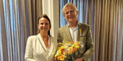 Burgemeester Nadine Stemerdink op de foto met Nick van Dasselaar. Hij heeft net een lintje gekregen van de burgemeester en staat met een bos bloemen op de foto.
