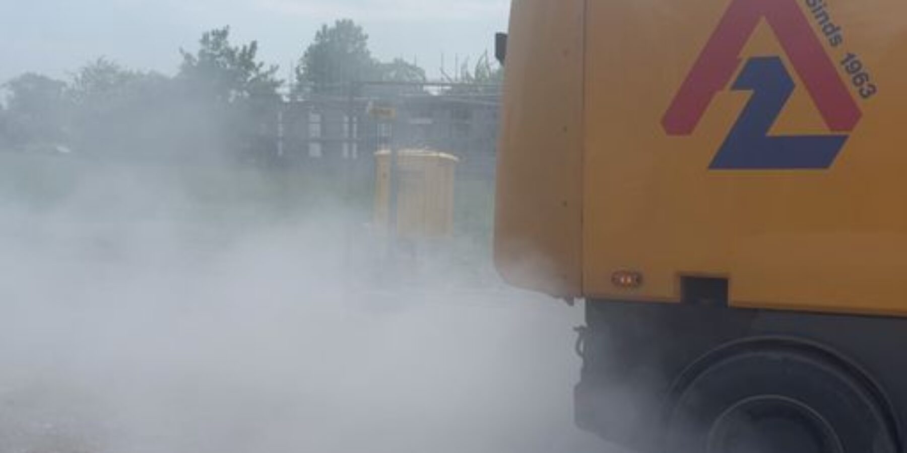 Bewoners slaan alarm om stof en gezondheidsklachten bij bouwweg. Op de foto rijdt een auto weg en waait er stof op.