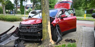 Auto tegen een boom op de Veluwemeerlaan in Leiden. De auto is flink beschadigd.