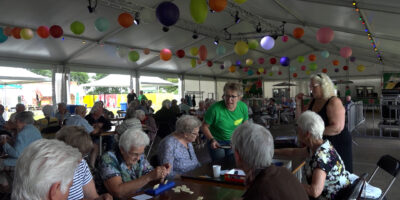 Senioren spelen rummikub in de tent van Dorpsfeest Zoeterwoude.