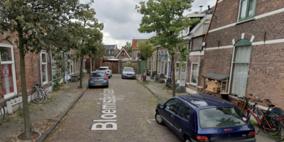 De stoep aan de Bloemistenlaan in Leiden wordt verhoogd. Een inkijkje in de straat met de stoepen aan beide kanten en geparkeerde auto's.
