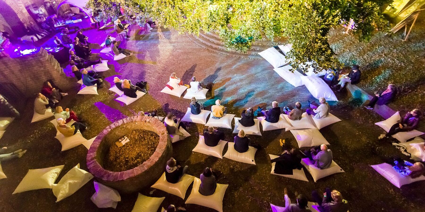 Het van RIJN festival op de Burcht in Leiden. Het publiek zit op zit zakken te genieten van cultuur.