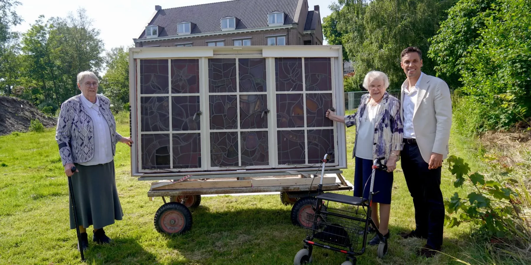 Twee Zusters van het klooster op de Buitenplaats Bijdorp in Voorschoten overhandigen een glas-in-lood raam aan een investeerder.