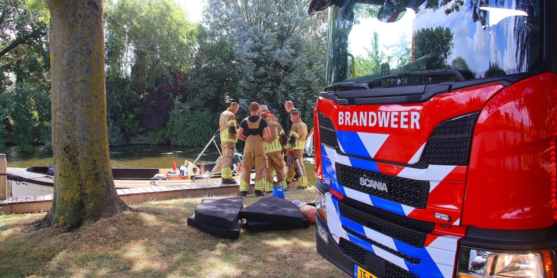 De brandweer bij de boot, waarvan de motor overhit was. Dit was aan de President Kennedylaan in Oegstgeest. Melding brand vaartuig.