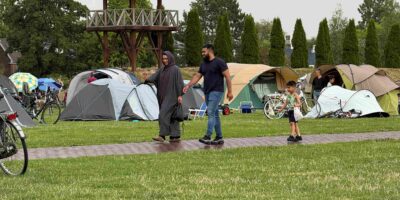 Bezoekers wandelen tussen de tenten tijdens De Buurtcamping in Park Matilo in Leiden, waar ontmoeting en verbinding centraal staan.