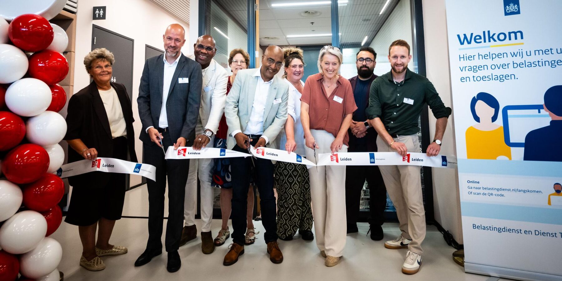 Unitdirecteur Bjorn Meijer (Belastingdienst), wethouder Abdelhaq Jermoumi (gemeente Leiden) en Thera Olthof (gemeente Leiden) openen het steunpunt in het Stadskantoor van de gemeente Leiden, in bijzijn van medewerkers Dienstverlening van de Belastingdienst en medewerkers van Burgerzaken van de gemeente Leiden.