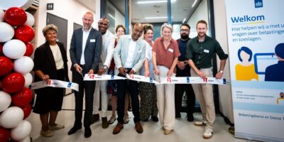 Unitdirecteur Bjorn Meijer (Belastingdienst), wethouder Abdelhaq Jermoumi (gemeente Leiden) en Thera Olthof (gemeente Leiden) openen het steunpunt in het Stadskantoor van de gemeente Leiden, in bijzijn van medewerkers Dienstverlening van de Belastingdienst en medewerkers van Burgerzaken van de gemeente Leiden.