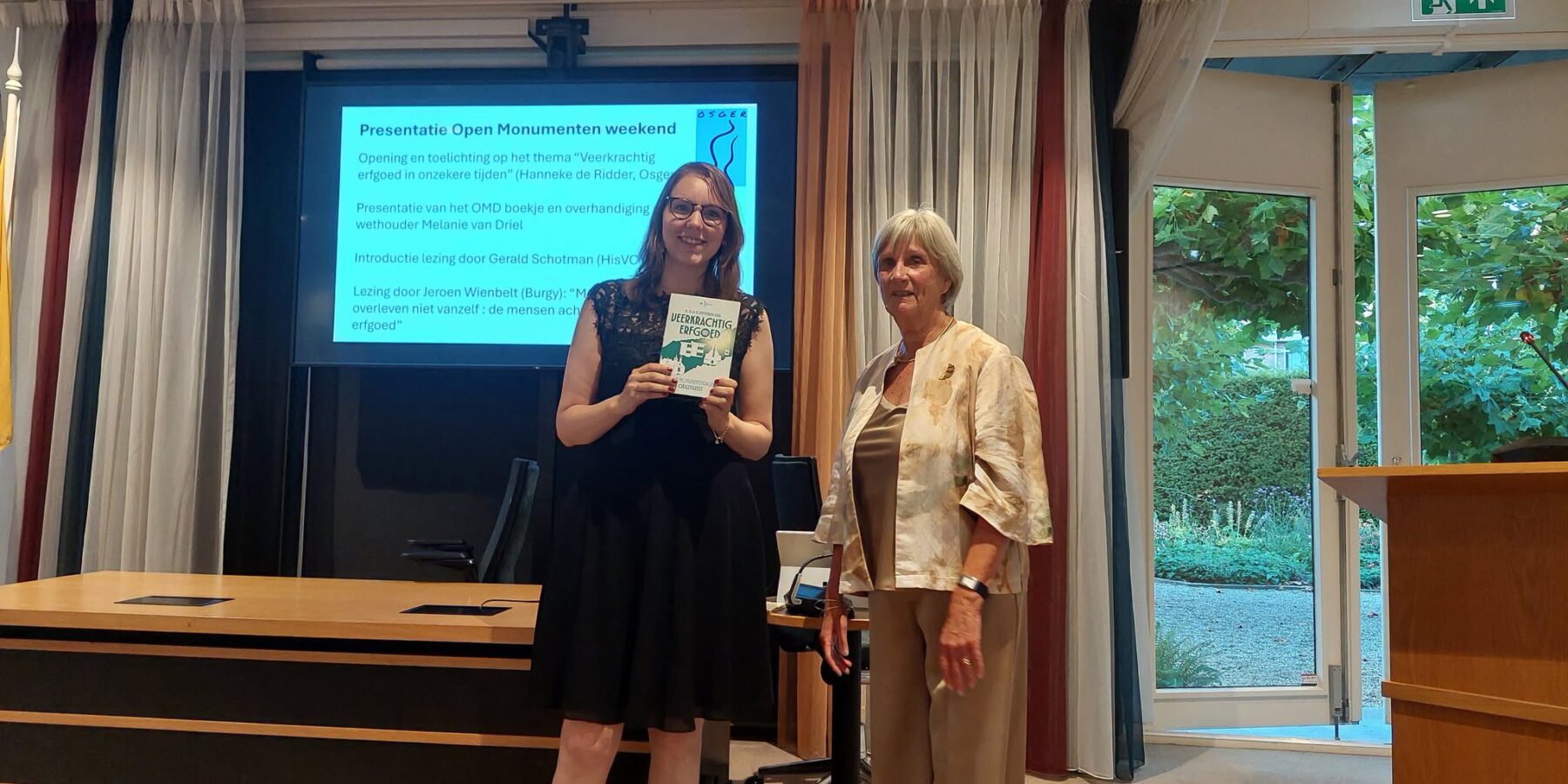 Programmaboekje open monumentendagen in Oegstgeest overhandigd aan wethouder Melanie van Driel.