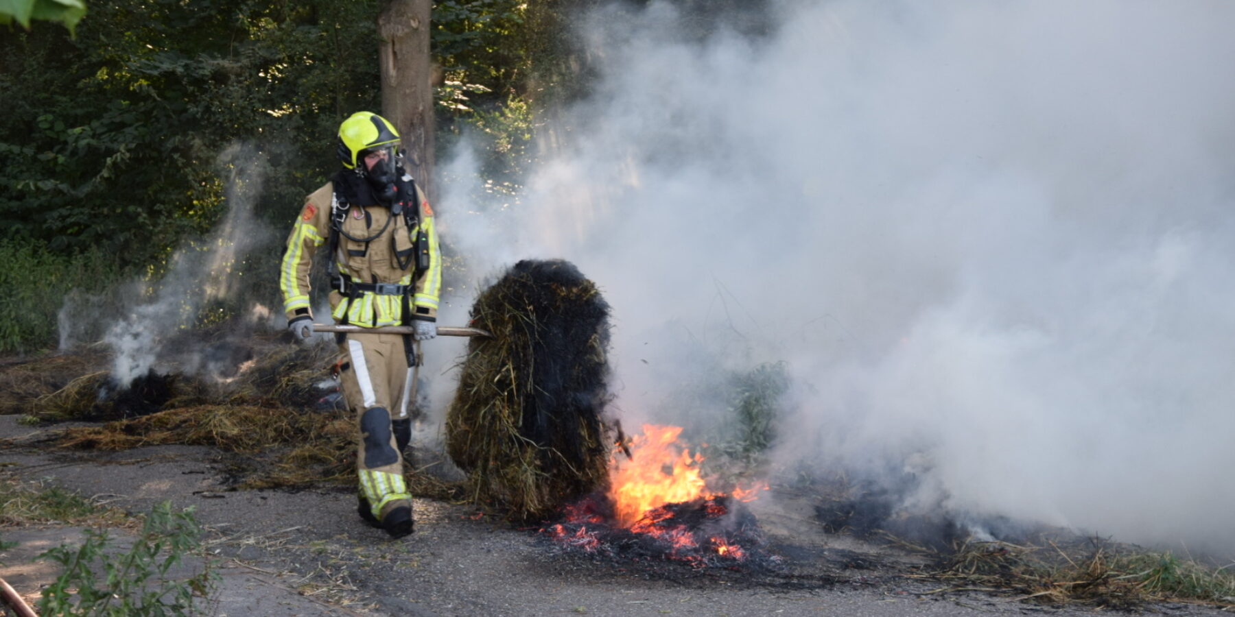 Brandweer werkt aan de brandende groenstapel bij Park de Houtkamp.