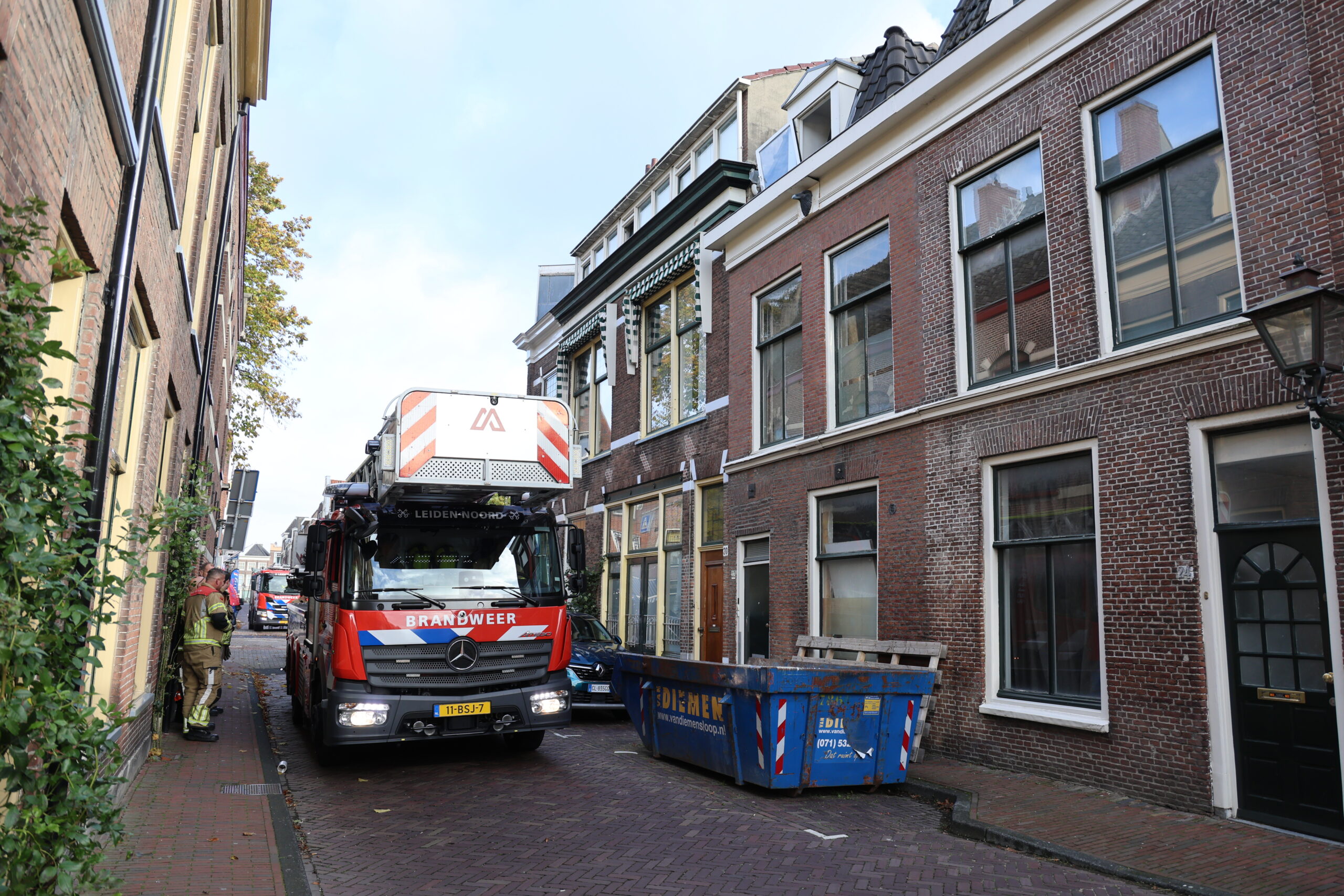 De brandweer onder het losgewaaide raam aan de Kraaijerstraat (Foto: Regio15)
